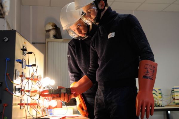 Formation à l’habilitation électrique, avec port d’équipements de protection individuelle adaptés : gants en matériaux isolants, casque de protection, outil isolant