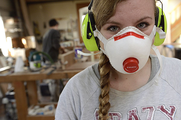 atelier d’ébénisterie utilisant un système d’aspiration centralisée et des masques de protections respiratoires pour réduire les expositions aux poussières de bois