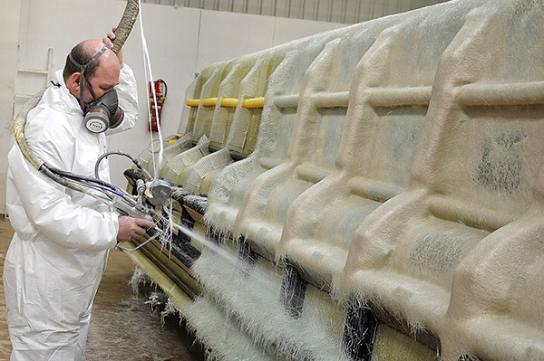 Fabrication de piscines en matériaux composites : poste de projection de fibre de verre et de résine